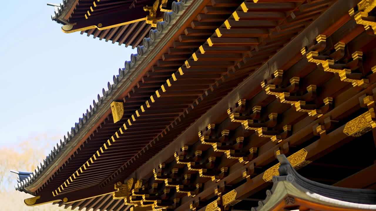 Vista detallada de la arquitectura tradicional de templo asiático con aleros dorados