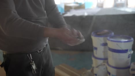 construction worker clapping dusty dirty cement hands shaking off dust