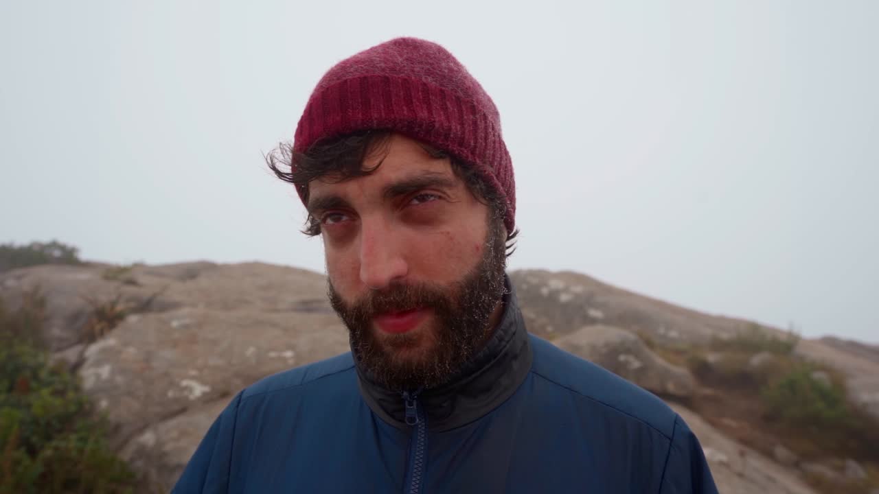Bearded man with wet face from mist stares seductively in Mantiqueira, Minas Gerais, Brazil