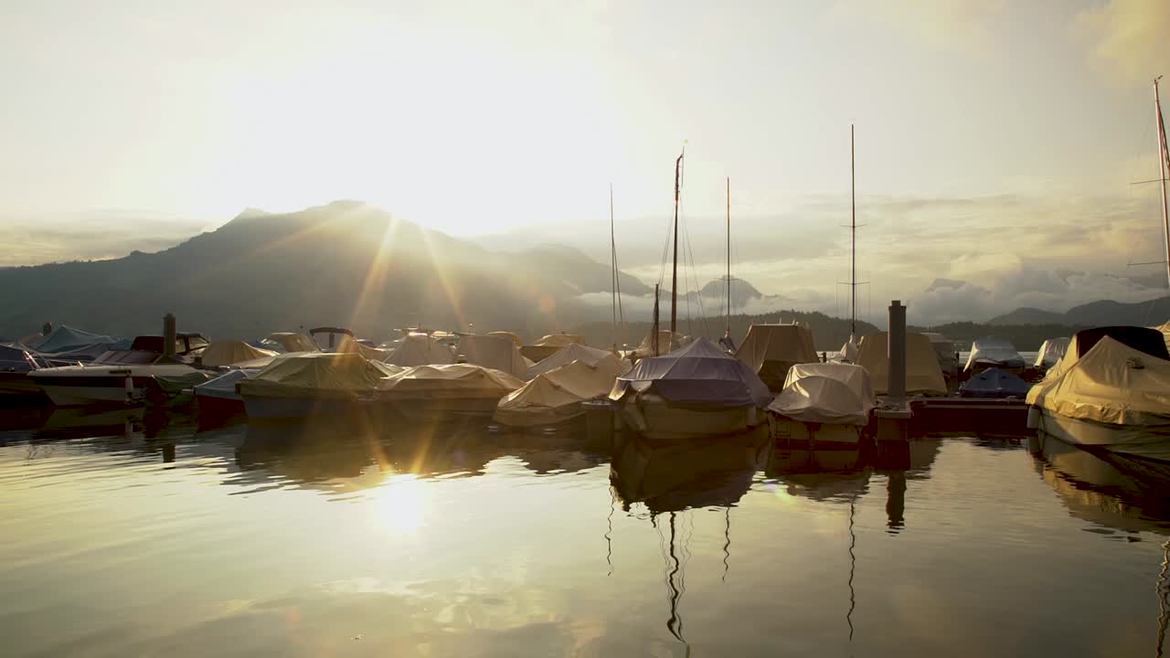 Golden sunrise reflection on Lucerne lake waterfront and harbor, Switzerland