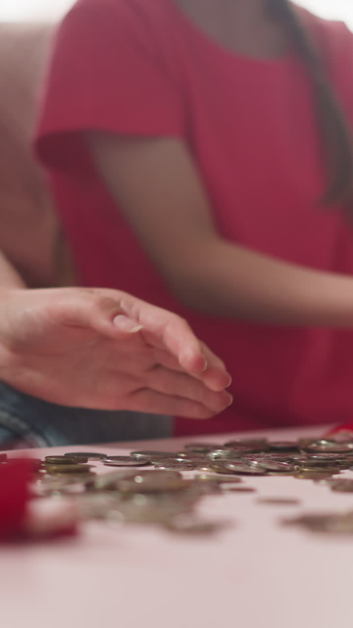 Little boy with mother gathers scattered coins while girl sits nearby at home closeup slow motion. Happy family breaking piggy bank. Money and budget
