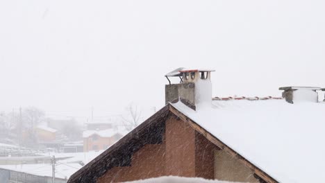 snowfall over a roof with a chimney