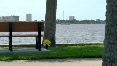 Parklandschaft-Am-Flussufer-Mit-Architektur,-Bank,-Boot-Und-üppigem-Gras