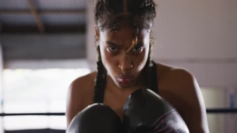 mixed race woman using boxing gloves