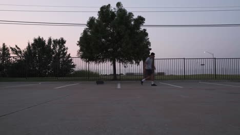 wide side view of male skateboarder failing to perform a kickflip at an outdoor parking lot