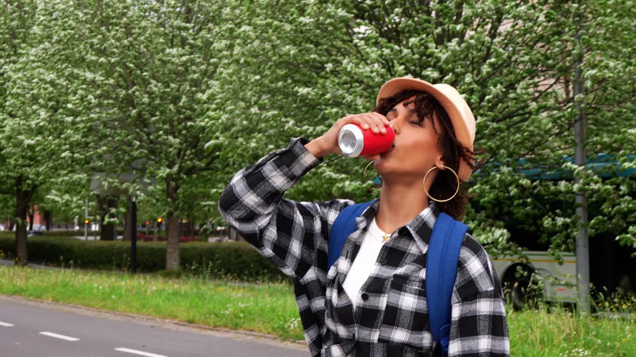 Seorang wanita minum soda di luar ruangan
