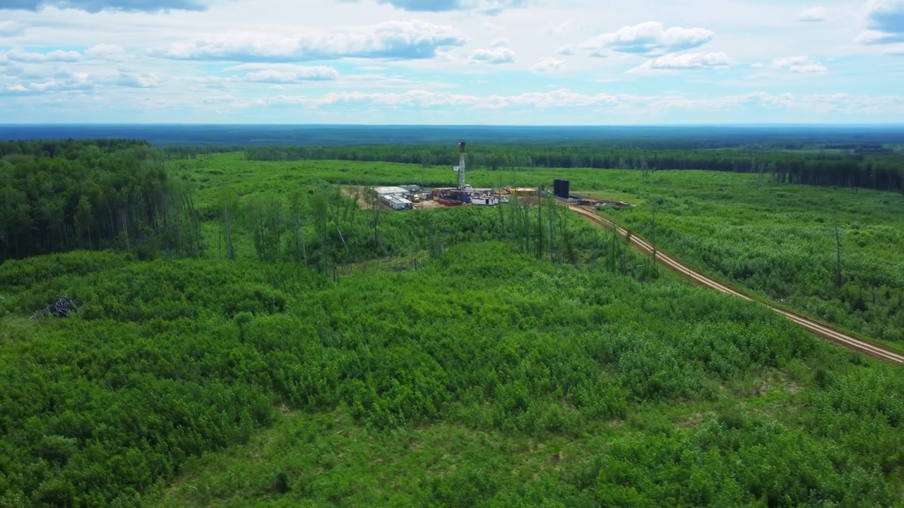 Revealing Aerial Shot of a Drilling Rig and Gravel Road, Alberta, Canada