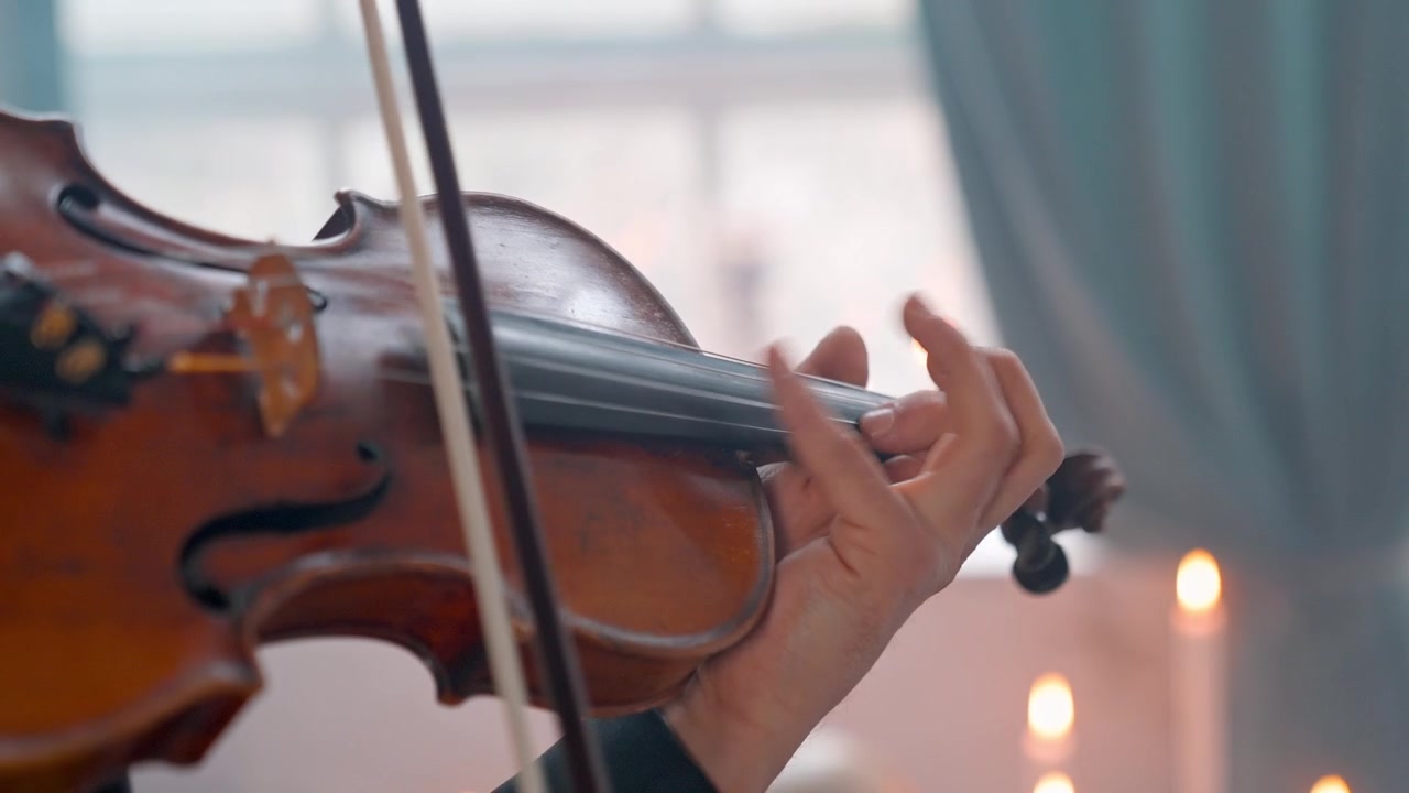 Primo piano di un musicista che suona il violino con archetto e dita