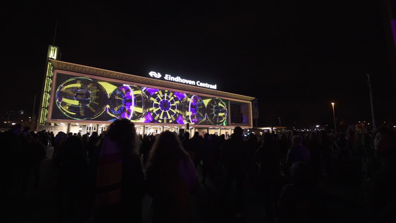 Magical patterns on building exterior in Eindhovel glow festival, pan right view