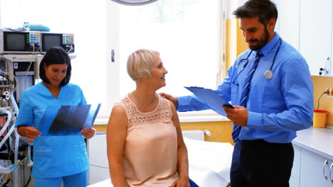 médico masculino interactuando con un paciente mientras la enfermera mira la radiografía
