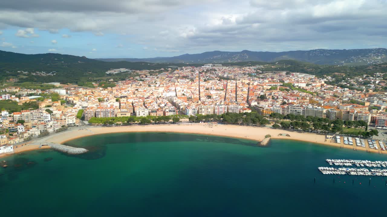 Picturesque sant feliu de guixols graces the costa brava coastline, its sandy beach and turquoise waters framed by a charming urban landscape and verdant hills
