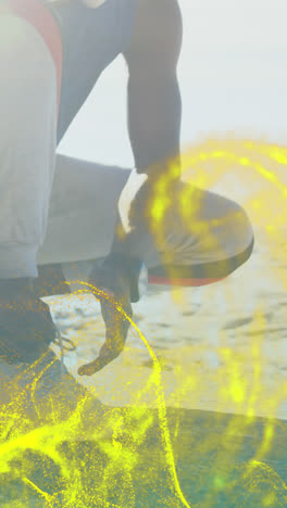 Golden-digital-wave-against-african-american-fit-man-tying-his-shoe-laces-at-the-beach