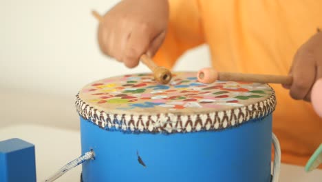 child playing a colorful drum