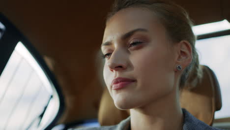 Close-up-serious-businesswoman-talking-with-partner-at-backseat.-Woman-face