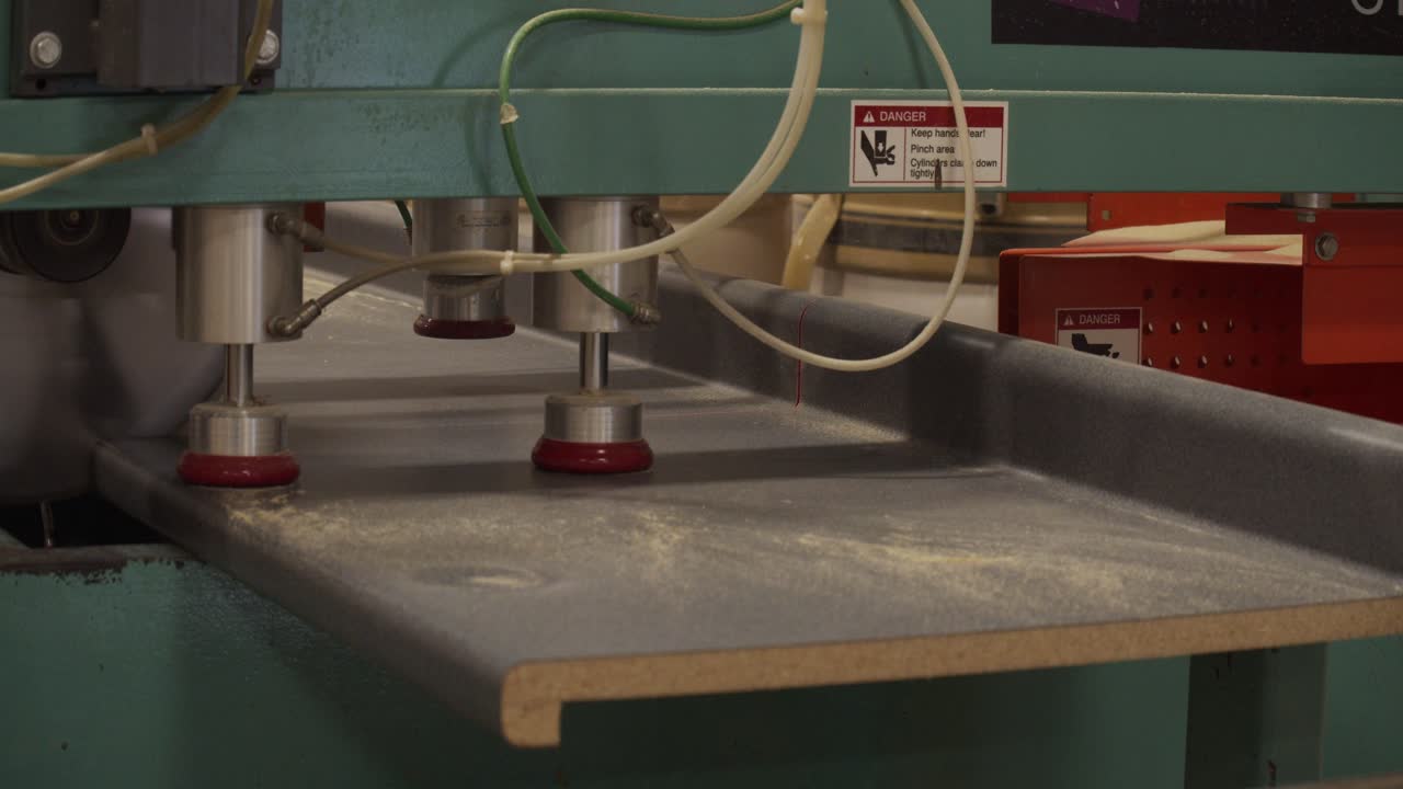 Close up of an industrial table saw cutting a length of kitchen counter in a factory environment