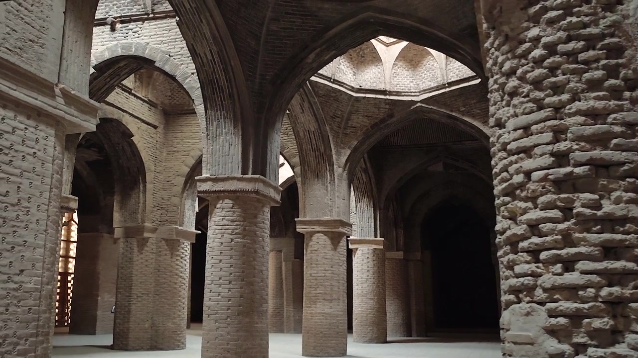 Interno di un'antica moschea in mattoni con colonne ad arco.