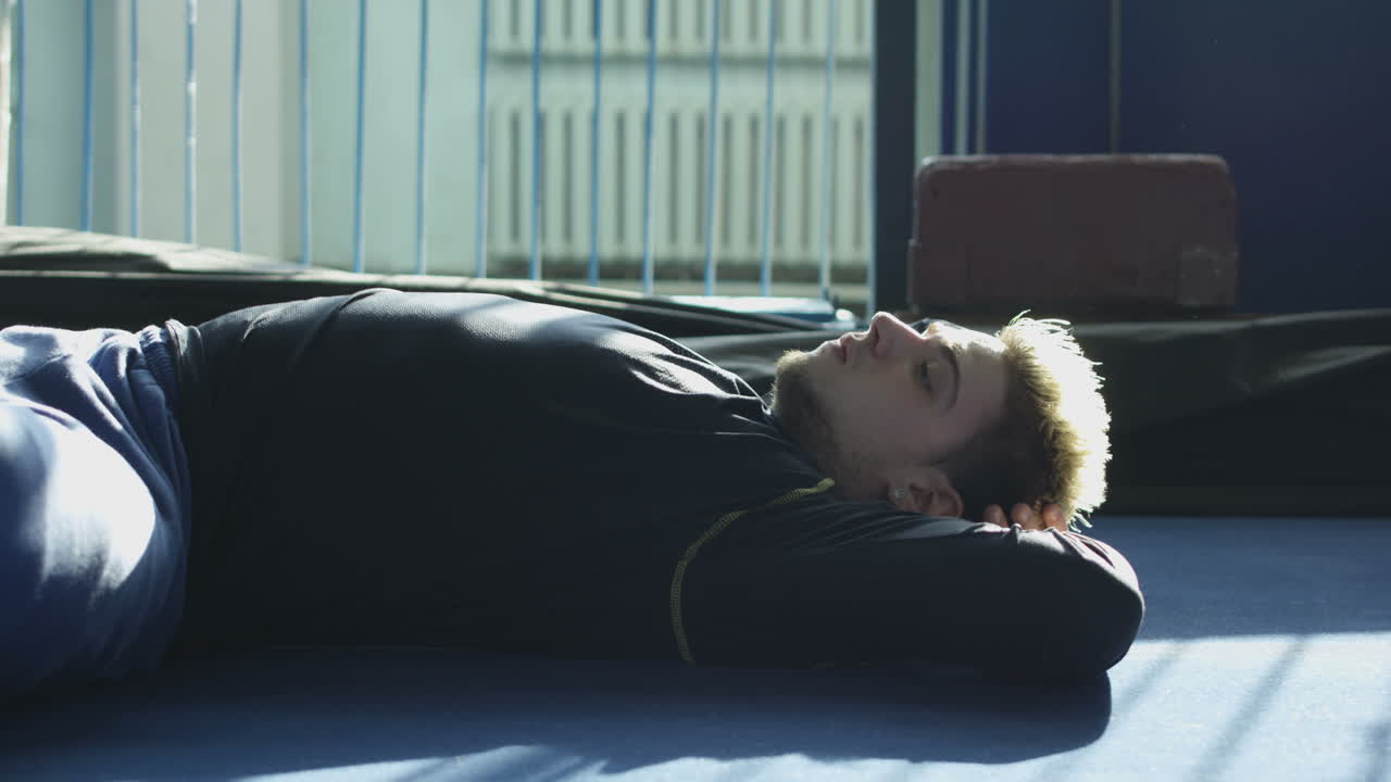 A tired man laying on the gym floor