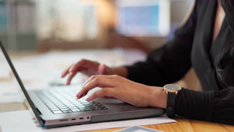 hands of woman in office, typing on laptop