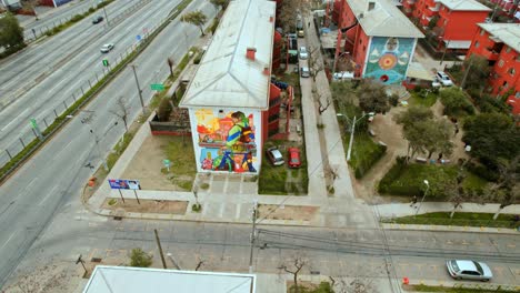 aerial: orbiting a building wall with unique art at the san miguel museum in chile