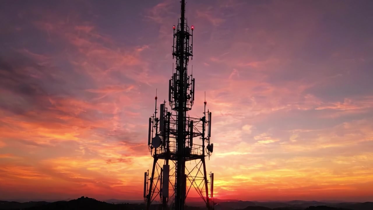 Un Tramonto Sereno che si Affaccia su un'Imponente Struttura di Comunicazione Contro un Cielo Vibrante, Catturato in Due Splendide Inquadrature che Mostrano la Gloria della Natura e la Portata della Tecnologia