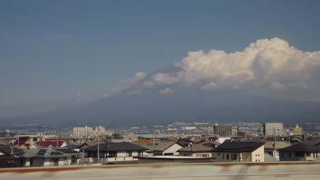 mt fuji passing by in background seen from seat on bullet train to tokyo