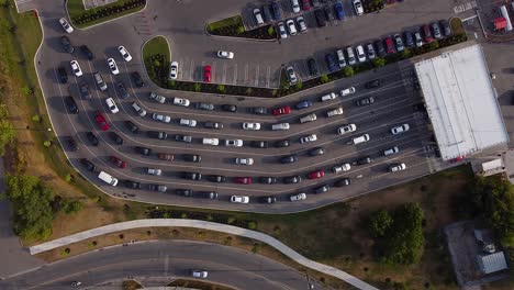 static drone shot of cars and vehicles lined up at gas station to buy fuel during pandemic shortage