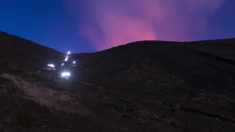 el resplandor del volcán sobre el descenso de los faros de los excursionistas de islandia