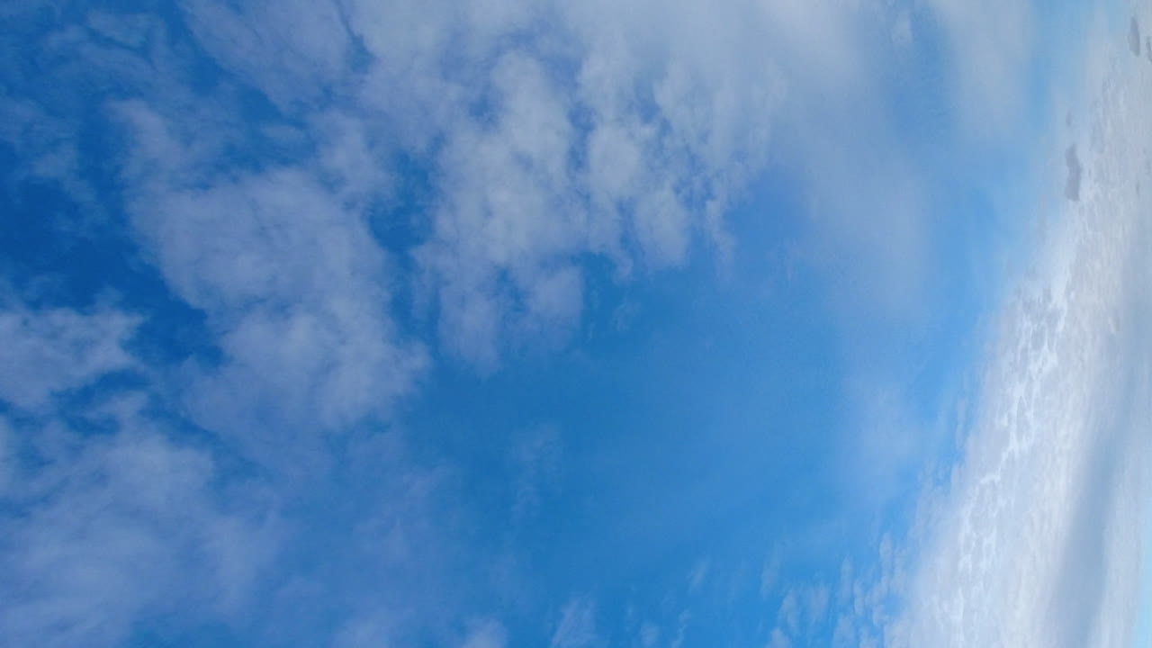 세로 형식: 저속으로 푸른 하늘을 가로지르는 얇은 적운 구름