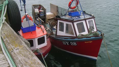 a shot of two fishing vessels docked on a pontoon