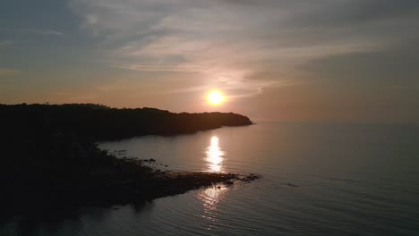Round-orange-sun-Amazing-aerial-top-view-flight-natural-beach-bay-thailand,-wood-pier-golden-hour,-lagoon-koh-kood-2022