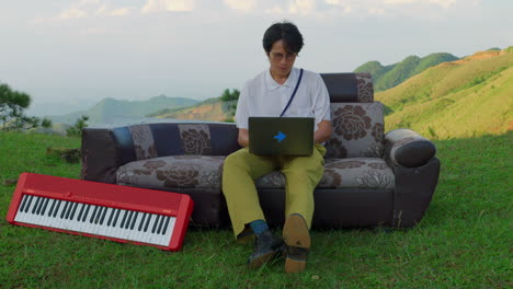 man working on laptop and keyboard in nature