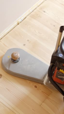 edge sander refinishing wooden floor. overhead vertical shot