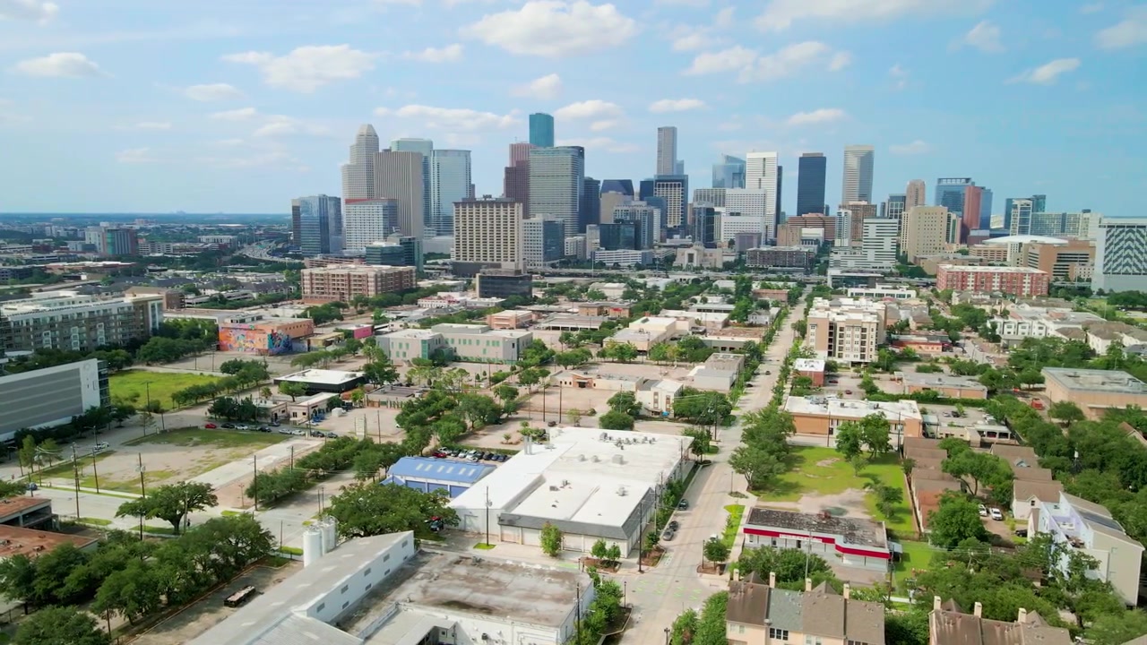 Skyline del centro di Houston ripreso da drone aereo dalla veduta panoramica di East Downtown con un'inclinazione fluida della telecamera verso l'alto, che mostra moderni grattacieli sotto nuvole drammatiche durante il giorno a Houston, T