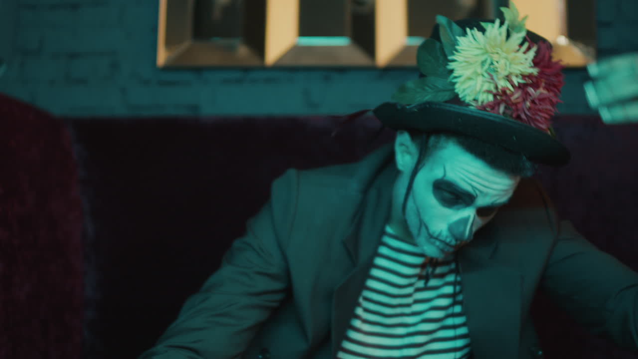 젊은이가 앉아서 카메라를 쳐다보고 있습니다.