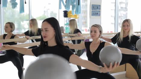 people of different ages doing pilates exercises with fitness ball during group training at gym. high quality 4k footage