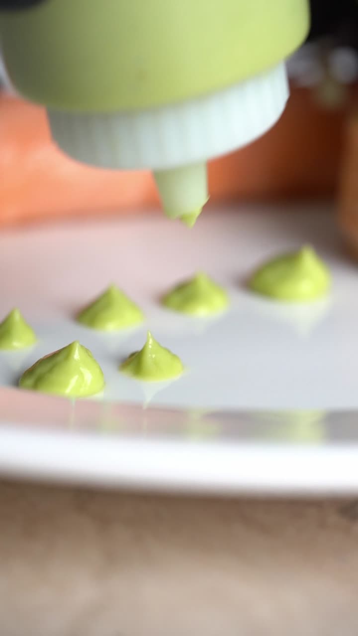 Uno chef mette salsa verde su un piatto. Ripresa ravvicinata, inserto.