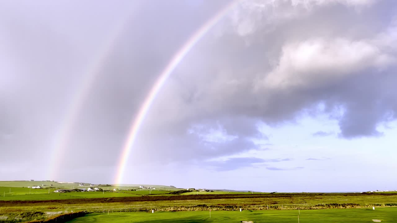 arco iris doble sobre paisaje verde en irlanda