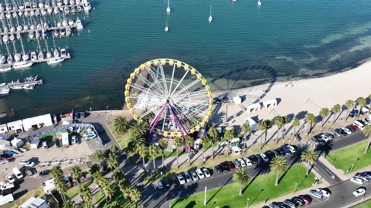High wide drone footage of Ferris wheel near beach