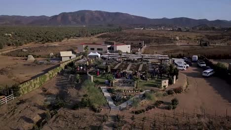 Drone-Volando-En-Círculos-Una-Fiesta-De-Bodas-En-Una-Casa-Grande-En-Medio-De-Un-Valle