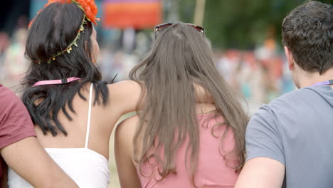 back view of friends sitting talking at a music festival