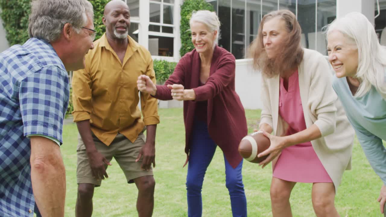 Animation of happy diverse female and male senior friends playing american football in garden