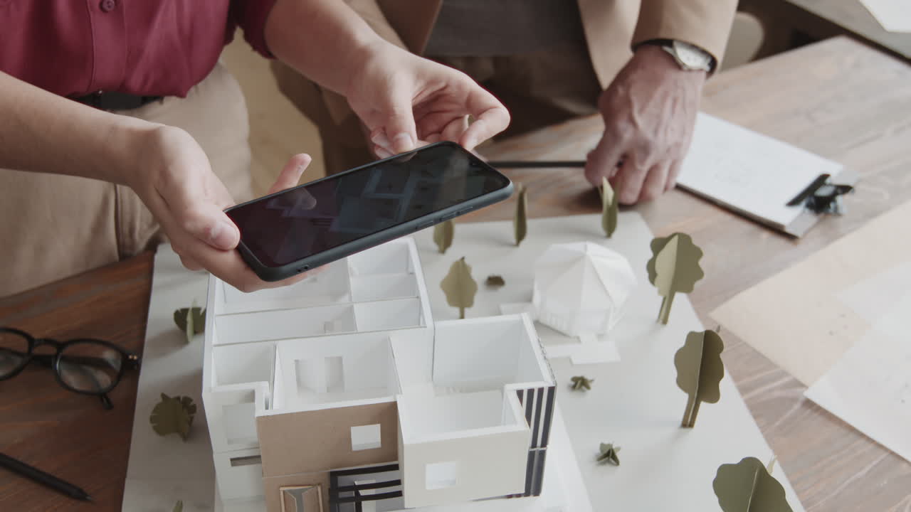 Architects Taking Top-View Shot Of 3D House Model