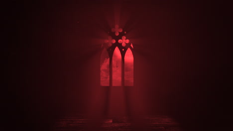 window of old castle with red light and crosses in night