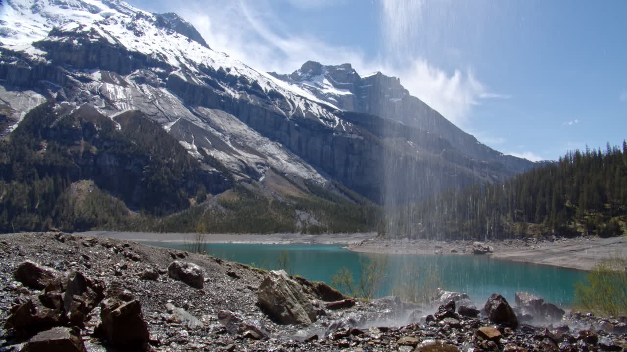 una fina cascada cae desde el acantilado de arriba, mirando desde atrás podemos ver un escenario maravilloso donde la naturaleza se une con todas sus características