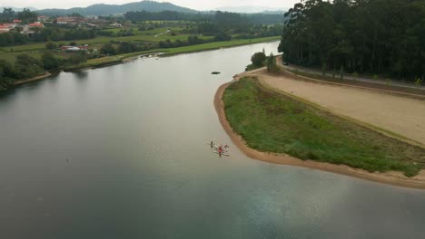 Aerial-of-canoers-embarking-on-Cavado-River-journey,-Esposende-Portugal