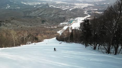 Mire-A-Un-Snowboarder-Masculino-Navegar-Sin-Miedo-Por-Las-Laderas-Negras,-Mostrando-Habilidades-Impresionantes-En-Los-Resorts-De-Yabuli