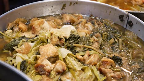 close up footage of chinese vegetables soup, cabbage, spinach, lettuce or seasonal vegetables and pork belly boiled for hours