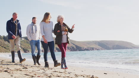 Pareja-Mayor-Caminando-Por-La-Costa-Con-Hijos-Adultos-En-Vacaciones-De-Invierno-En-La-Playa