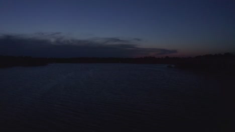 rising aerial wide shot of a midwestern lake during twilight