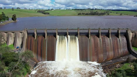 slow forward moving and panning down aerial footage of water being released from lauriston reservoir, in central victoria. october 2022.